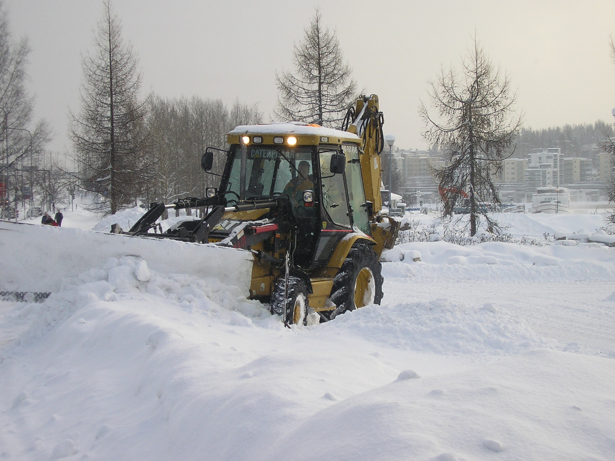 backhoe plowing snow on commercial property