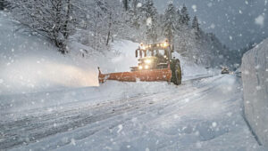 snow plow plowing through storm