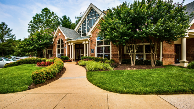 Commercial property landscaping with seasonal flower beds at community entrance